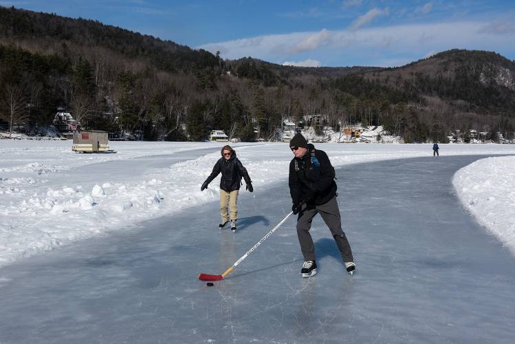 Sue Haidul, left, and her husband Joe, right, of Boston, skate a short trail on Lake Morey as the 4.3-mile ice skating trail around the lake, splitting off at left, remains closed on Friday, Feb. 11, 2022. This season's variable temperatures and wet snow frozen into the surface of the ice have made the longer trail difficult to maintain. (Valley News - James M. Patterson) Copyright Valley News. May not be reprinted or used online without permission. Send requests to permission@vnews.com.