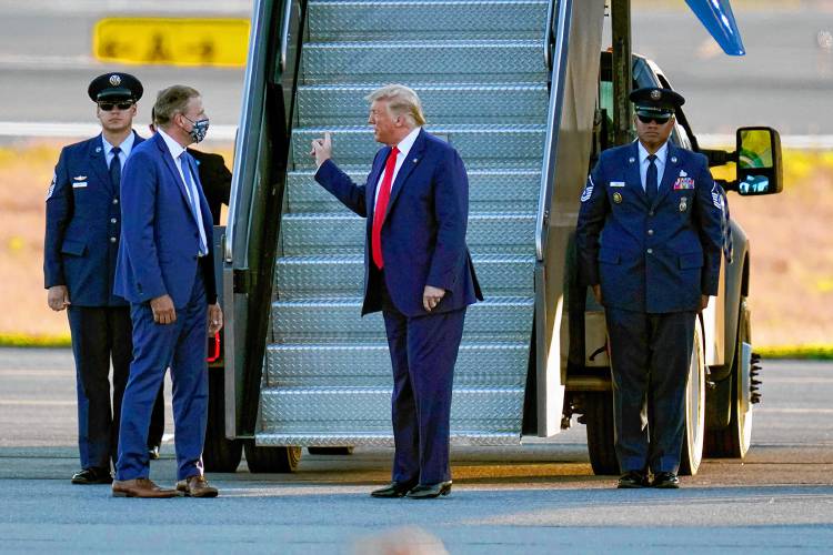 President Donald Trump is greeted by New Hampshire Gov. Chris Sununu, left, as he arrives for a campaign rally at Manchester-Boston Regional Airport, Friday Aug. 28, 2020 in Londonderry, N.H. President Trump easily won the February New Hampshire Republican primary. (AP Photo/Charles Krupa, File)
