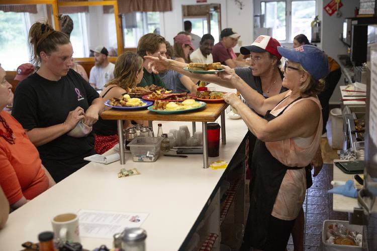 From left, server Catherine Sturgeon picks up a breakfast order for her table while owner Janice Neil and line cook Dara Towle prepare food behind the counter at Jan’s Fairlee Diner in Fairlee, Vt., on Friday, July 5, 2024. Neil said the diner has seen increased traffic since the start of the detour and now with the addition of summer visitors and holiday travel they occasionally start the day with a line into the parking lot. (Valley News - Alex Driehaus) Copyright Valley News. May not be reprinted or used online without permission. Send requests to permission@vnews.com.
