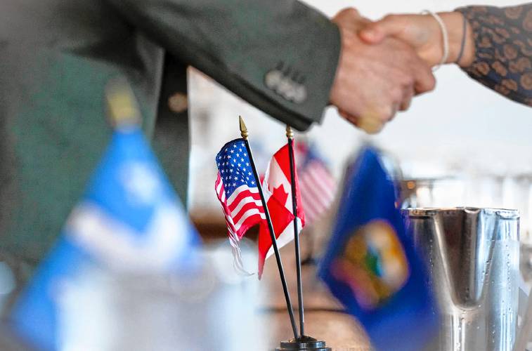 Attendees shake hands before the start of a roundtable discussion on the possible effects of tariffs and a trade war between the U.S. and Canada in Newport, Vt., on March 18, 2025. (VtDigger - Glenn Russell)