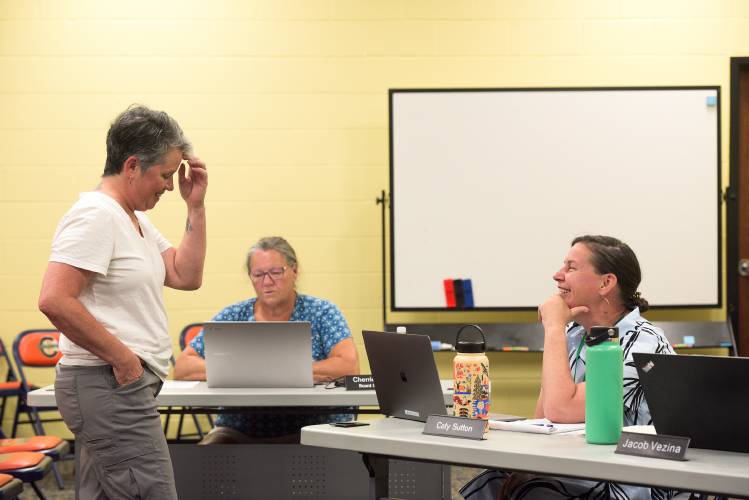Linda Saturley, president of the Hartford Education Association and a teacher at White River School, left, introduces herself to Caty Sutton, right, Hartford's curriculum director and interim superintendent, before a special meeting of the Hartford School Board in White River Junction, Vt., on Thursday, July 18, 2024. During the meeting Saturley, speaking for herself, questioned School Board Chair Kevin Christie about the fiscal resposibility of accepting former Superintendent Tom DeBalsi's retirement and agreeing to pay his full salary through June, 2025. Cherrie Torrey, board secretary is in the background. (Valley News - James M. Patterson) Copyright Valley News. May not be reprinted or used online without permission. Send requests to permission@vnews.com.