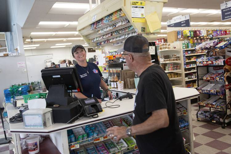 Miranda Locke talks to customers as she works the register at Wings Market and Deli in Fairlee, Vt., on Friday, July 5, 2024. Locke said business has picked up as a result of the detour, and the gas station has run out of fuel at least twice due to high demand, despite being set up for automatic deliveries from their supplier. (Valley News - Alex Driehaus) Copyright Valley News. May not be reprinted or used online without permission. Send requests to permission@vnews.com.