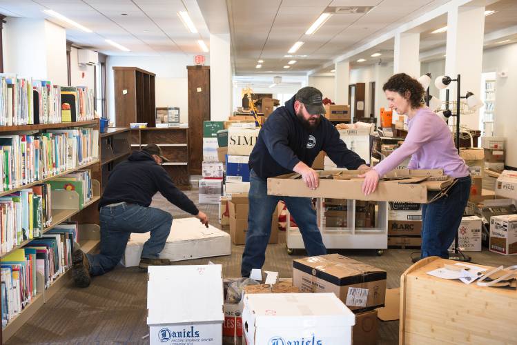 Dan Quimby, a building maintenance worker, middle, hands off packing materials to Enfield Public Library Director Kate Minshall, right, while assembling new furniture with Assistand Road Director Don Lashua, left, for the children's room in Whitney Hall in Enfield, N.H., on Tuesday, Jan. 21, 2025. Staff are moving back into the library after a renovation and addition that brings the building into ADA compliance adds three meeting rooms and a teen room and increases the overall space by almost 70%. (Valley News - James M. Patterson) 