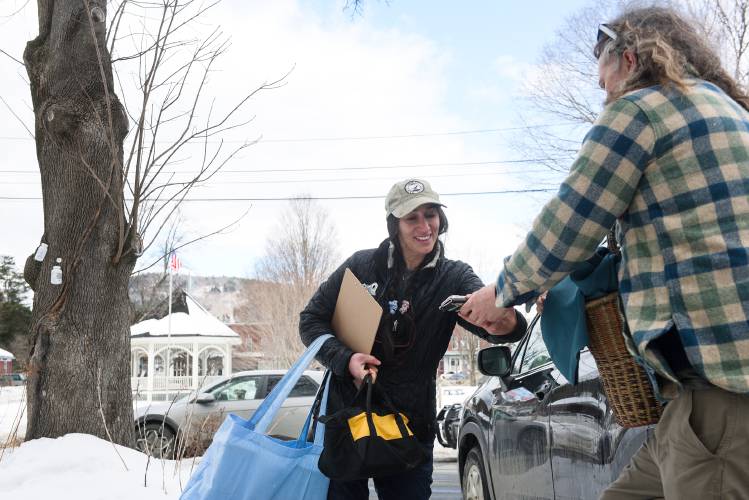 Emily Sigman, left, a PhD student in Dartmouth's Ecology, Evolution, Environment and Society program, center, exchanges contact information with Seth Lazuli, right, who noticed her sampling bottles hanging on trees in Vermont on Wednesday, Feb. 26, 2025. Sigman is sampling in areas with known contamination, which can include around older buildings where lead paint has gotten into the soil. “The last thing I want to do is have there be less maple syrup making in the world,” said Sigman. She said her goal is not to scare people about contaminated sap, but that she is trying to, “suss out what are the risks and possibilities of sugar making in non-traditional places.” (Valley News - James M. Patterson) Copyright Valley News. May not be reprinted or used online without permission. Send requests to permission@vnews.com.