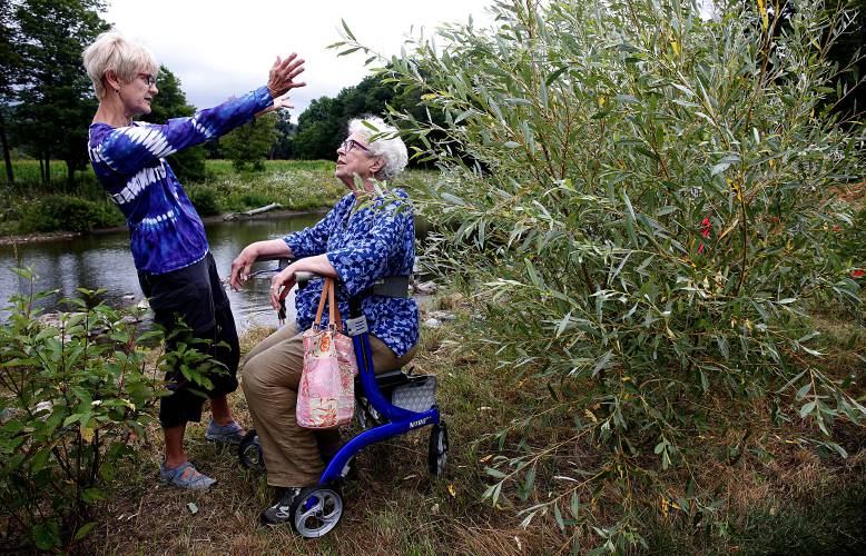 Mary MacVey, of Woodstock, Vt., left, speaks with Peggy Kannenstine, also of Woodstock, about the perennial plants Kannenstine donated for a rain garden at the new East End park on the Ottauquechee River in Woodstock on Aug. 5, 2017. MacVey is a volunteer for Sustainable Woodstock, part of an effort since 2009 to redevelop the former railyard. 