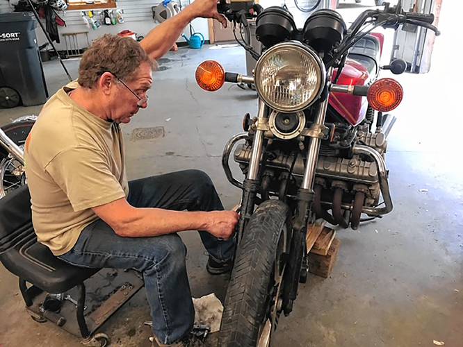 Jimmy Proctor works on a 1980 Honda CBX in his shop, a big six cylinder motorcycle, in an undated photograph. (Family photograph)