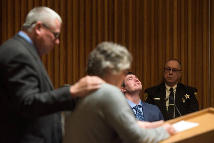 Kyle Clampitt cries at right in Grafton Superior Court in North Haverhill, N.H., on Monday, April 14, 2025, as his mother Sue Clampitt asks Judge Jonathan Frizzell for leniency in sentencing  him for the 2022 rape of a Dartmouth college freshman at a fraternity party when he was 24-years-old. Clampitt was sentenced to 17 to 40 years in prison after being found guilty of 10 counts of aggravated felonious sexual assault at trial in January. Clampitt's father David Clampitt is at left. (Valley News - James M. Patterson) 