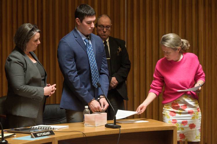 Grafton Superior Court Clerk Viktoriya Kovalenko, right, provides Kyle Clampitt, middle, with a notice of requirement to register as a sex offender at the close of his sentencing hearing as his attorney Robin Melone stands at left, in North Haverhill, N.H., on Monday, April 14, 2025. Clampitt received a sentence of 17 to 40 years in prison after being found guilty at trial in January to 10 counts of aggravated felonious sexual assault of a Dartmouth College freshman at a fraternity party in Hanover, N.H. in 2022. (Valley News - James M. Patterson) 
