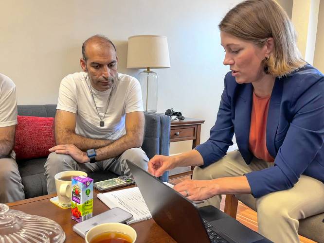 Molly Gray, executive director of Vermont Afghan Alliance, walks an Afghan client through a request form to be sent to U.S. Rep. Becca Balint, D-Vt. His reunification case has been pending for 233 days. (Chloe Jad photograph)
