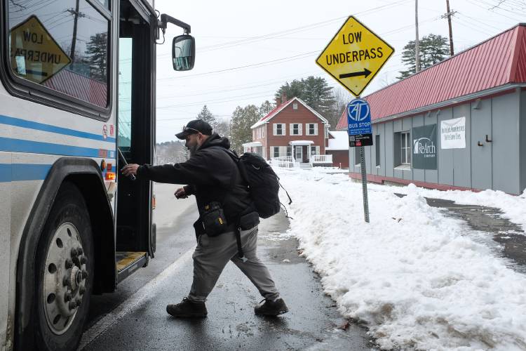 Anthony Crear, of Lebanon, boards a bus outside the emergency homeless shelter under construction on Mechanic Street in Lebanon, N.H., on Tuesday, Jan. 9, 2024. 