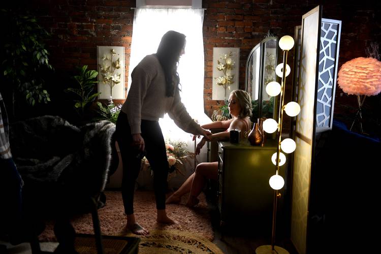 Les Bella Boudoir associate photographer Sarah McEnany adjusts Shelby Soulia's position while photographing her at the studio in Claremont, N.H., on Tuesday, Jan. 9, 2024. It was Soulia's third visit to the studio for a photography session.  (Valley News - Jennifer Hauck) Copyright Valley News. May not be reprinted or used online without permission. Send requests to permission@vnews.com.