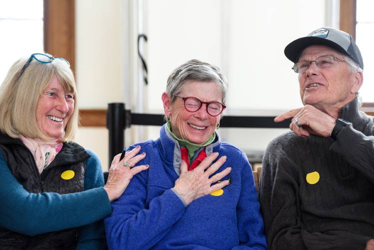 Candee Brohinsky, middle, laughs with Lynda Shannis, left, and Ray Shannis, right, after she voted as part of a unanimous approval of an article determining the split of property taxes to be payed in two installments over the fiscal year, then also spoke a lone 
