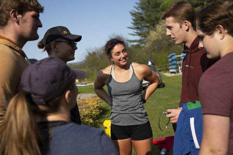 Clockwise from center, Lebanon High School senior Anna Numme, 18, talks with her teammates junior Carson Boardman, sophomore Joshua Jordan, junior Abigail Stone, junior Caleb Jordan and junior Toms Linkaits before crew practice with the Upper Valley Rowing Foundation at Kendal Riverfront Park in Hanover, N.H., on Thursday, May 18, 2023. Numme started attending Lebanon High School this year after taking classes at a community college her junior year, and found her footing quickly through sports like wrestling and rowing. “This is my favorite school so far,” she said. (Valley News / Report For America - Alex Driehaus) Copyright Valley News. May not be reprinted or used online without permission. Send requests to permission@vnews.com.