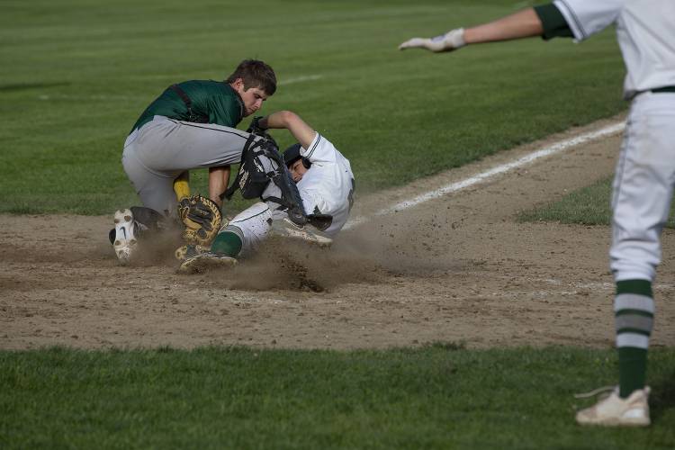Windsor catcher Tanner Moody (6) attempts to tag out Woodstock’s Josh Hough (20) as he slides into home plate while his teammate Riley O’Neal (4) gestures that he is safe during a varsity baseball game at Windsor High School in Windsor, Vt., on Thursday, May 16, 2024. Woodstock won, 27-5. (Valley News / Report For America - Alex Driehaus) Copyright Valley News. May not be reprinted or used online without permission. Send requests to permission@vnews.com.