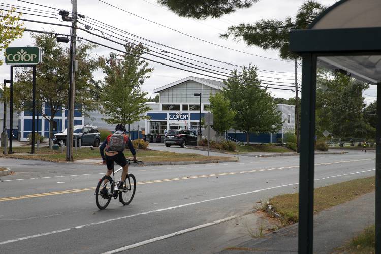 A cyclist passes the Co-op Market on Lyme Road in Hanover, N.H., on Tuesday, Sept. 24, 2024. The market, which has been operating at a loss for several years, is closing on October 18, following a denial from the Hanover Zoning Board of Adjustment to turn the location into a commercial kitchen. (Valley News - Alex Driehaus) Copyright Valley News. May not be reprinted or used online without permission. Send requests to permission@vnews.com.