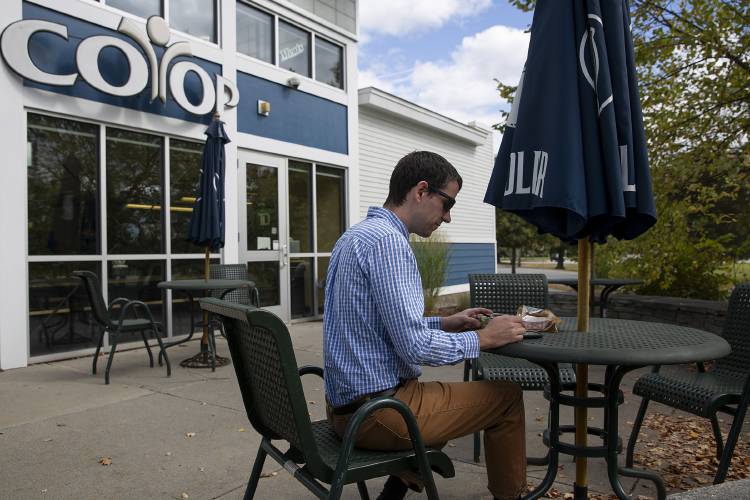 Aaron Meyer, of Lebanon, N.H., eats his lunch on the patio of the Co-op Market on Lyme Road in Hanover, N.H., on Tuesday, Sept. 24, 2024. Meyer sighed as he thought of the additional time he will have to put toward prepping his lunches each week after the closing of the Co-op and Cutting's Northside Cafe. “Hanover is an expensive place to do business,” he said of the financial hurdles faced by both businesses. (Valley News - Alex Driehaus) Copyright Valley News. May not be reprinted or used online without permission. Send requests to permission@vnews.com.