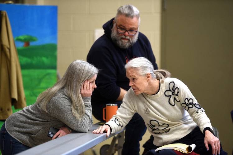 Lyme residents Kristin Roth, left, Toby Summerfield and Elizabeth Glenshaw discuss a Town Meeting article during the Lyme Town Meeting on Tuesday, March 11, 2025, in Lyme, N.H.  (Valley News-Jennifer Hauck)