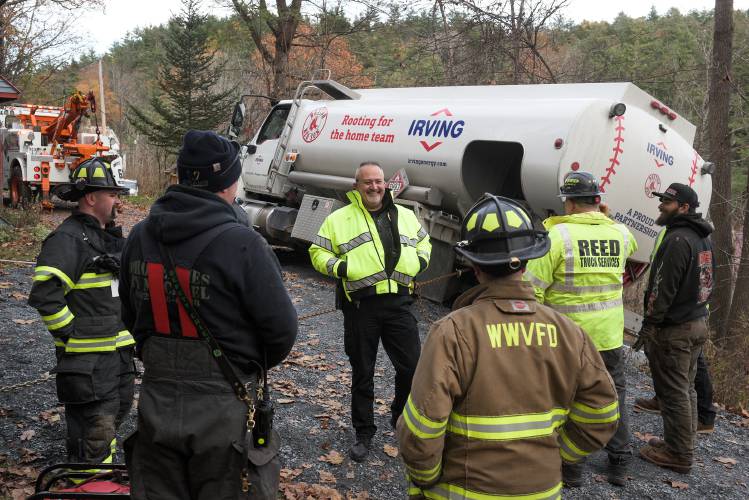 Weathersfield Police Chief Bill Daniels, center, talks with firefighters and vehicle recovery workers as they stabilize a heating oil truck that slid off a driveway in West Weathersfield, Vt., on Wednesday, March 26, 2025. (Valley News - James M. Patterson) Copyright Valley News. May not be reprinted or used online without permission. Send requests to permission@vnews.com.