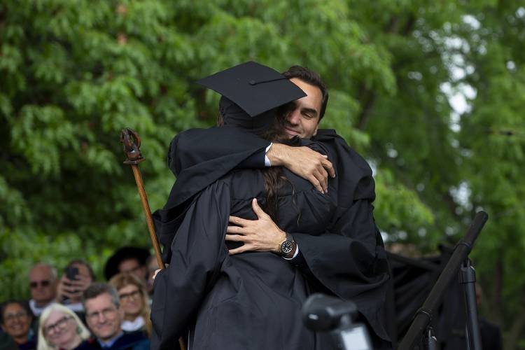 Commencement speaker and former professional tennis player Roger Federer, right, hugs Isabella Godsick, daughter of his longtime manager Tony Godsick, as she walks across the stage during the Dartmouth College commencement ceremony on the green in Hanover, N.H., on Sunday, June 9, 2024. (Valley News - Alex Driehaus) Copyright Valley News. May not be reprinted or used online without permission. Send requests to permission@vnews.com.