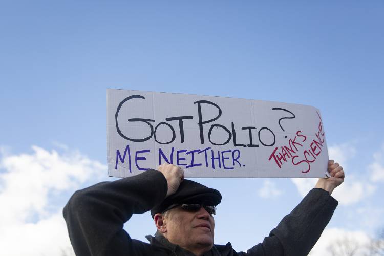 John Gilman, of Weathersfield, Vt., holds up a sign made by his wife, Julie, during a Stand Up for Science protest on the Dartmouth Green in Hanover, N.H., on Friday, March 7, 2025. (Valley News - Alex Driehaus)
