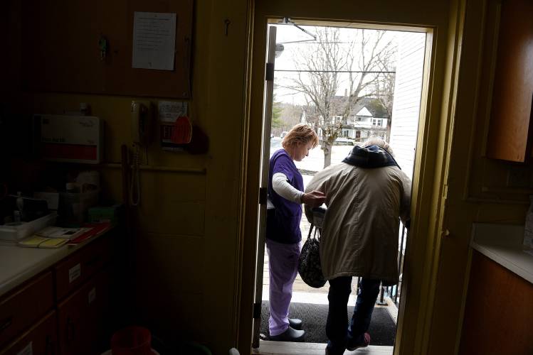 After spending about an hour together, parish nurse Missy Ball helps client Geri Burgess down the stairs at the Lyme Congregational Church on Tuesday, March 25, 2025. Burgess often comes to see Ball on Tuesdays when she sees clients at church. (Valley News-Jennifer Hauck)