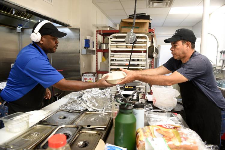 Restaurant workers Jean Alain Charles, left, and Germain Pierre work on an order at The Karibbean in West Lebanon, N.H., on Friday, July 26, 2024. Both men are originally from Haiti. The restaurant makes Caribbean and Haitian food. (Valley News - Jennifer Hauck) Copyright Valley News. May not be reprinted or used online without permission. Send requests to permission@vnews.com.
