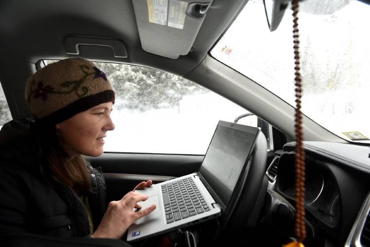 After driving through a snowstorm, Hartford Community Nurse Katie Williams logs into her laptop before visiting with a client in Hartford, Vt., on Thursday, Feb. 13, 2025. (Valley News-Jennifer Hauck)