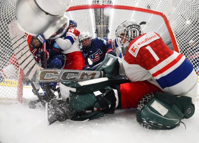 Dartmouth goalkeeper Michaela Hesova (1) battles for the puck with Czechia teammate Dominika Laskova (14) and USA’s Taylor Heise (27) at the  IIHF Women's World Hockey Championships on Friday, April 11, 2025, in Ceske Budejovice, Czechia. (International Ice Hockey Federation - Andrea Cardin)