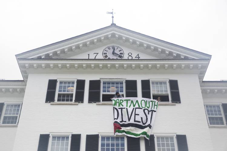 Protestors hang a “Dartmouth Divest” banner bearing the Palestinian flag from the windows of Dartmouth Hall during the Dartmouth College commencement ceremony on the green in Hanover, N.H., on Sunday, June 9, 2024. (Valley News - Alex Driehaus) Copyright Valley News. May not be reprinted or used online without permission. Send requests to permission@vnews.com.