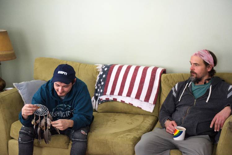 Joseph Nunes-Wales, left, looks at a dreamcatcher given to him by a friend in recovery at the Upper Valley Turning Point while relaxing with Chris Hoffman at Jack's House, a transitional living home for men in recovery from substance use in White River Junction, Vt., on Thursday, Feb. 27, 2025. Nunes-Wales said he is eager to hang up the gift in his room because he is early in his recovery and is having bad dreams. (Valley News - James M. Patterson) Copyright Valley News. May not be reprinted or used online without permission. Send requests to permission@vnews.com.
