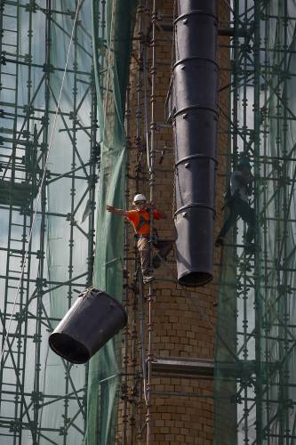 A crew from North Ridge Contracting assembles a chute for debris as they prepare to demolish the smokestack at Rivermill Commercial Center in Lebanon, N.H., on Friday, Sept. 20, 2024. (Valley News - Alex Driehaus) Copyright Valley News. May not be reprinted or used online without permission. Send requests to permission@vnews.com.