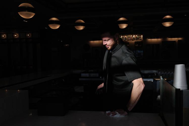 Casa Brava bar manager Austin Junker prepares to open the restaurant off the lobby of Six South Street Hotel in Hanover, N.H., on Saturday, Dec. 14, 2024. (Valley News - James M. Patterson) 