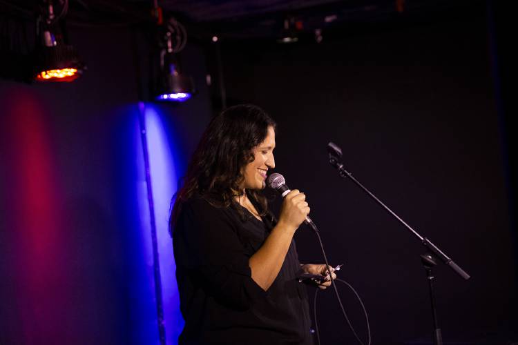 Krista Patronick, of Hanover, N.H., checks a notecard between jokes while performing her set at a comedy open mic event at Sawtooth Kitchen, Bar and Stage in Hanover, N.H., on Wednesday, Oct. 2, 2024. Patronick is working to add more gender diversity to the local comedy scene, and hosted a “Ladies Night” event featuring all women comics at Bright Side Brewing in West Lebanon in August. (Valley News - Alex Driehaus)