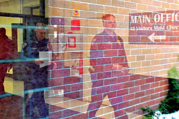 Woodstock Village Police Chief Joe Swanson, right, walks through Woodstock Union High School's main entrance while sweeping the building for an undisclosed threat in Woodstock, Vt., on Wednesday, Feb. 14, 2024. Officers from his department and the Windsor County Sheriff's office were at the school, which was closed for the day. (Rick Russell photograph)